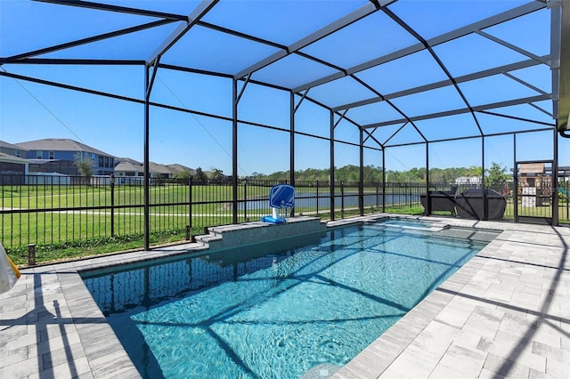 view of pool with glass enclosure, a patio, a yard, and fence