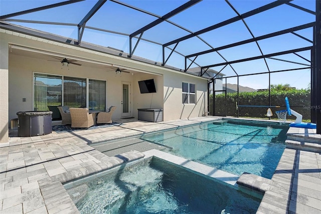 view of pool featuring glass enclosure, a pool with connected hot tub, ceiling fan, and a patio area