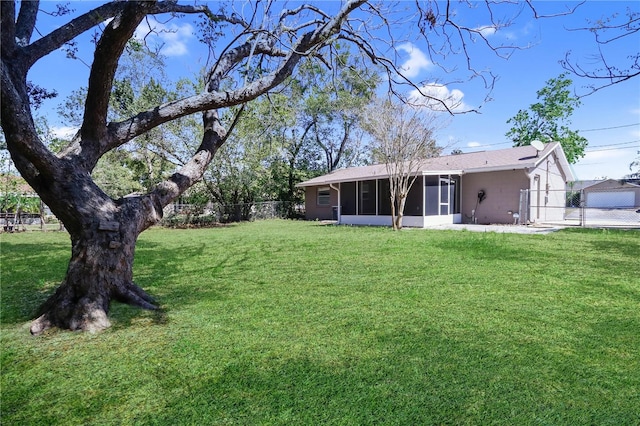 view of yard featuring fence and a sunroom