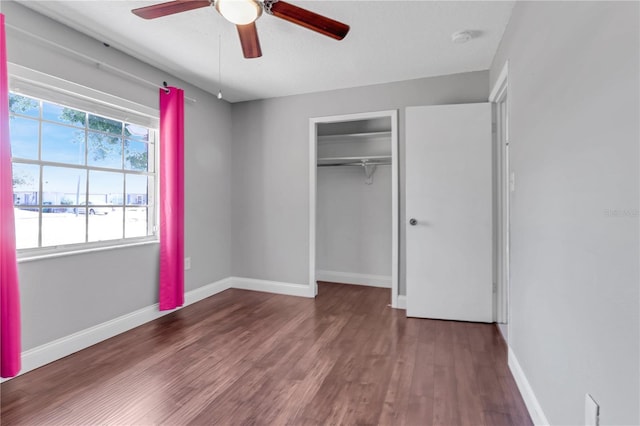 unfurnished bedroom with a closet, ceiling fan, baseboards, and wood finished floors