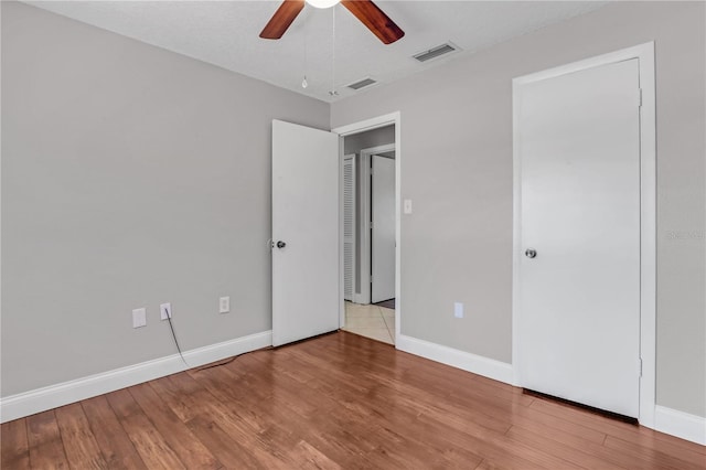 unfurnished bedroom featuring visible vents, baseboards, and wood finished floors