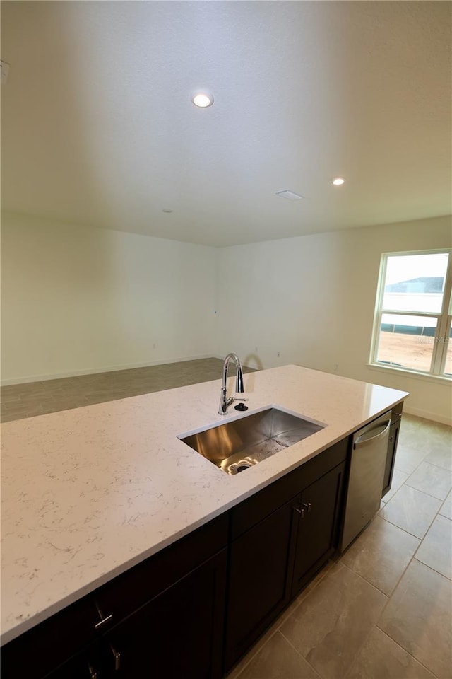 kitchen with a sink, stainless steel dishwasher, open floor plan, recessed lighting, and light stone countertops