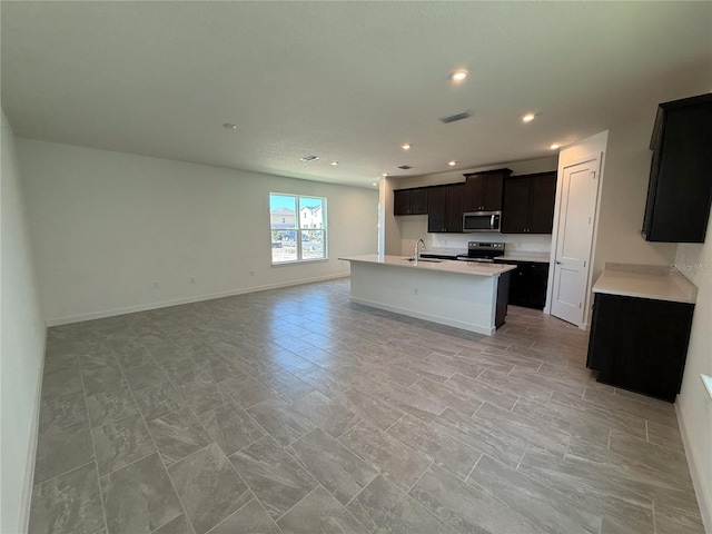 kitchen with visible vents, open floor plan, light countertops, stainless steel appliances, and a sink