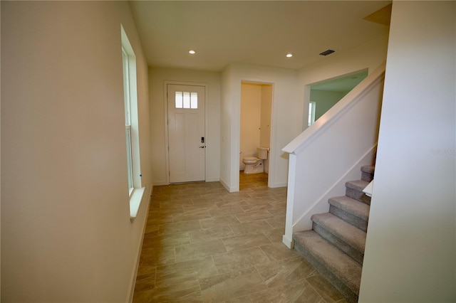 entryway with visible vents, recessed lighting, stairs, and baseboards