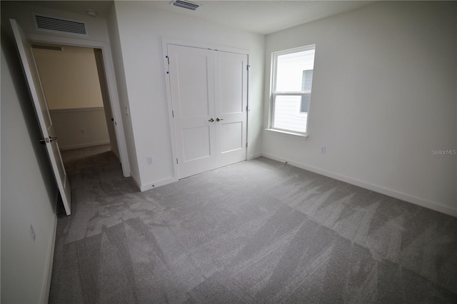 unfurnished bedroom featuring a closet, baseboards, visible vents, and carpet floors