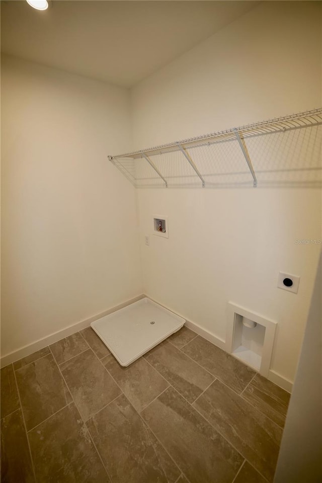 laundry area with laundry area, hookup for a washing machine, electric dryer hookup, and baseboards