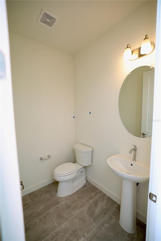 bathroom with visible vents, baseboards, and toilet