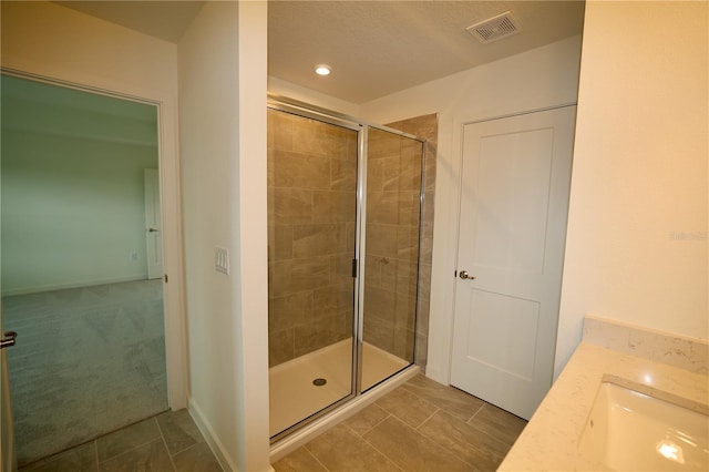 full bath with baseboards, visible vents, a sink, tile patterned flooring, and a shower stall