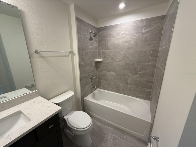 bathroom featuring washtub / shower combination, toilet, vanity, and a textured wall