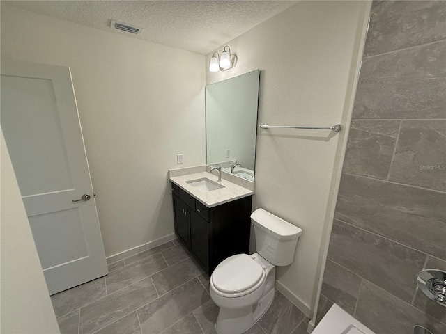 bathroom with vanity, baseboards, visible vents, a textured ceiling, and toilet