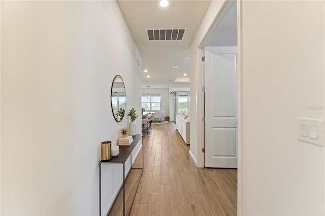 hall featuring light wood-type flooring, visible vents, and recessed lighting