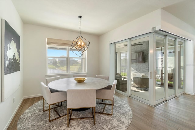 dining room featuring a notable chandelier, wood finished floors, and baseboards