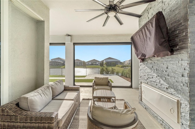 interior space with an outdoor hangout area, ceiling fan, and fence