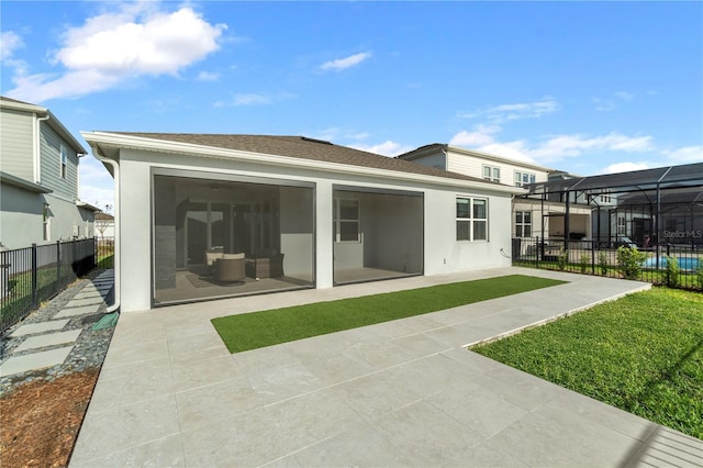 back of house featuring stucco siding, a patio area, a yard, and fence