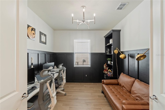 home office with a wainscoted wall, an inviting chandelier, visible vents, and wood tiled floor