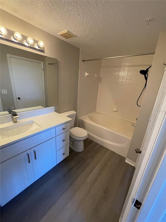 full bathroom featuring vanity, wood finished floors, visible vents, and a textured ceiling