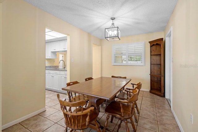 dining area featuring light tile patterned floors, a textured ceiling, and an inviting chandelier