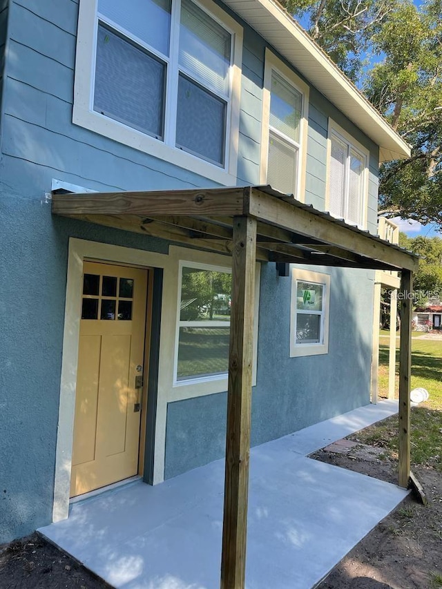 property entrance with stucco siding