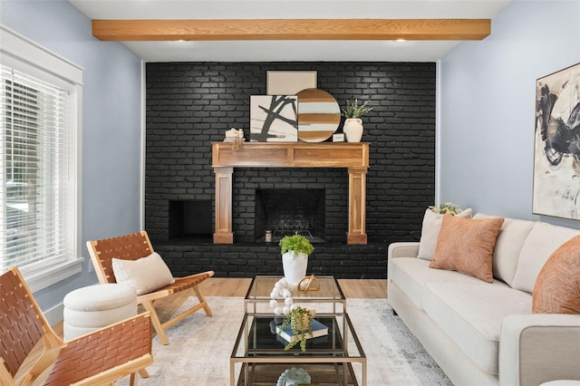 living room featuring beamed ceiling, a healthy amount of sunlight, and a fireplace