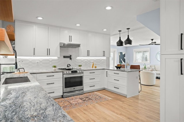 kitchen with light wood-style flooring, open floor plan, white cabinetry, stainless steel electric range, and a peninsula