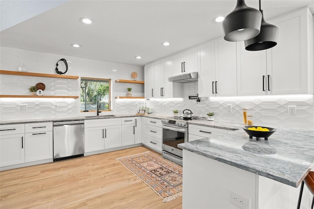 kitchen with open shelves, a peninsula, a sink, under cabinet range hood, and appliances with stainless steel finishes