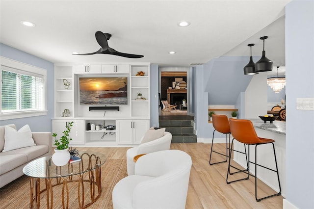 living room featuring recessed lighting, light wood-style flooring, and a ceiling fan