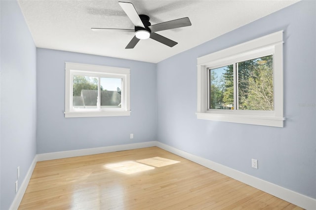 unfurnished room featuring a ceiling fan, wood finished floors, baseboards, and a textured ceiling