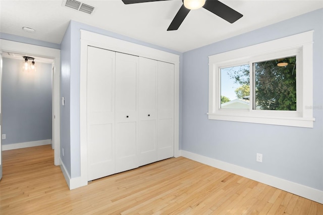 unfurnished bedroom featuring light wood-style flooring, baseboards, visible vents, and a closet