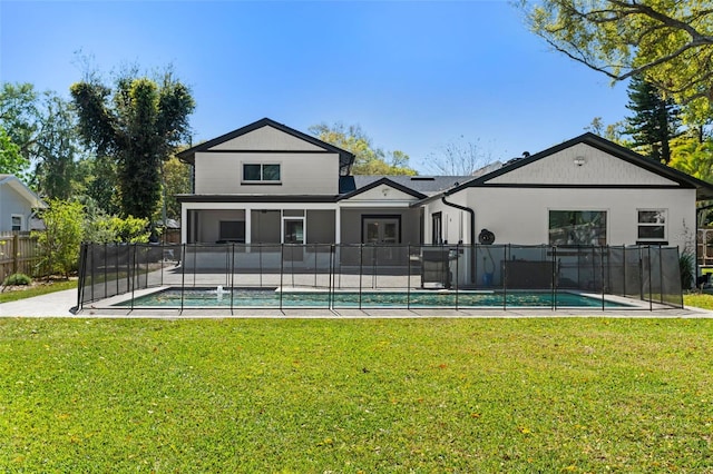 back of house with a fenced in pool, a lawn, and fence