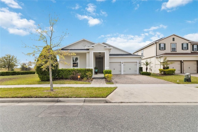 view of front facade featuring a front lawn, decorative driveway, and an attached garage