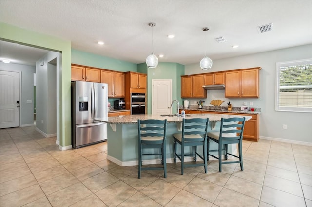 kitchen with a breakfast bar, visible vents, stainless steel appliances, and a sink