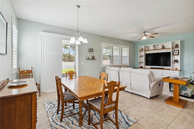 dining area featuring light tile patterned flooring and ceiling fan with notable chandelier