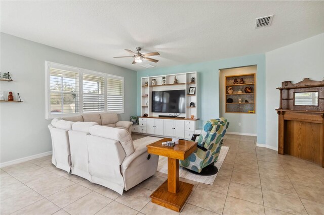 living room featuring built in shelves, baseboards, light tile patterned flooring, and a ceiling fan