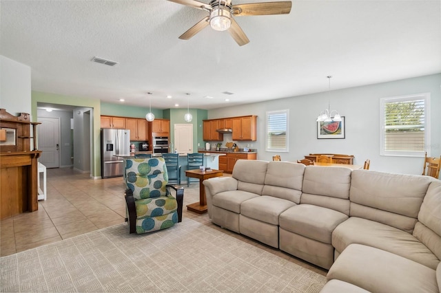 living area with recessed lighting, light tile patterned flooring, ceiling fan with notable chandelier, and plenty of natural light