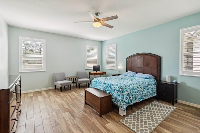 bedroom with light wood-style floors, baseboards, and ceiling fan