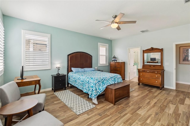 bedroom with a ceiling fan, baseboards, visible vents, light wood-style flooring, and connected bathroom