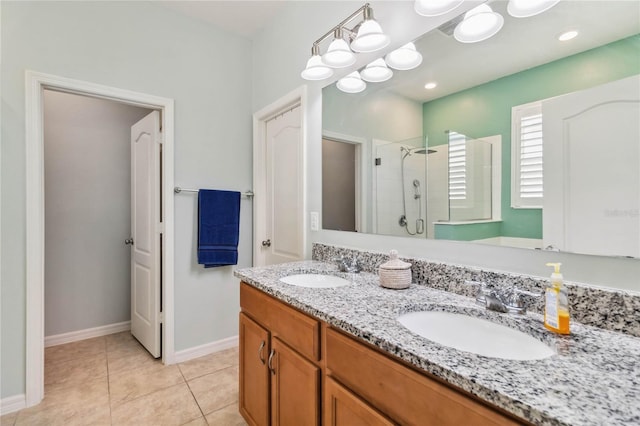 bathroom with tile patterned flooring, a stall shower, double vanity, and a sink