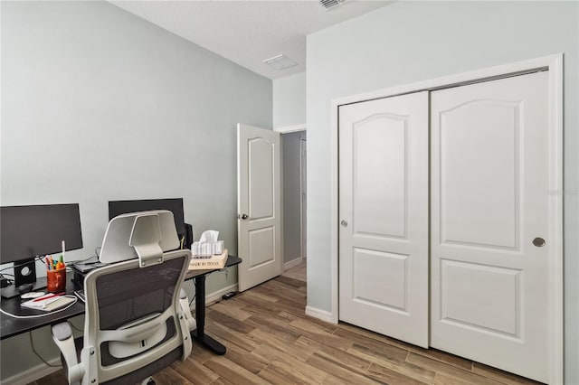 home office with light wood-style flooring and baseboards