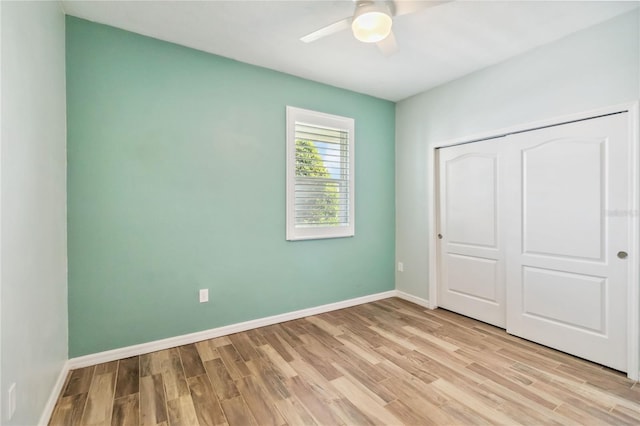 unfurnished bedroom with a closet, baseboards, light wood finished floors, and ceiling fan