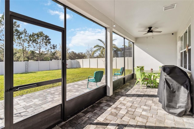 sunroom featuring visible vents and ceiling fan