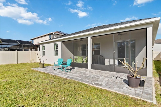 rear view of house featuring a patio area, a lawn, a sunroom, and fence