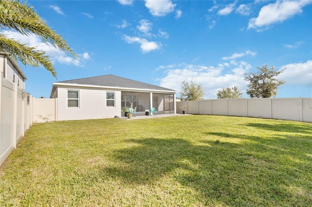 back of property featuring stucco siding, a lawn, a fenced backyard, and a sunroom