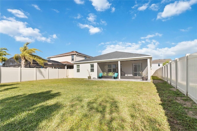 rear view of house featuring a lawn, a fenced backyard, and a sunroom