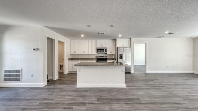 5963 Virtudes St, Sebring, FL 33872 - kitchen featuring appliances with stainless steel finishes, open floor plan, an island with sink, baseboards, and wood finished floors