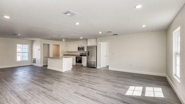 5963 Virtudes St, Sebring, FL 33872 - unfurnished living room featuring baseboards, recessed lighting, wood finished floors, a sink, and a textured ceiling