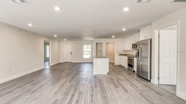 5963 Virtudes St, Sebring, FL 33872 - kitchen with stainless steel appliances, open floor plan, a sink, white cabinets, and light wood finished floors