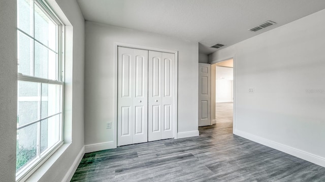 5963 Virtudes St, Sebring, FL 33872 - unfurnished bedroom featuring multiple windows, wood finished floors, and baseboards