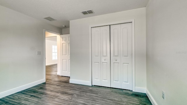 5963 Virtudes St, Sebring, FL 33872 - unfurnished bedroom with baseboards, dark wood-style floors, a closet, and a textured ceiling