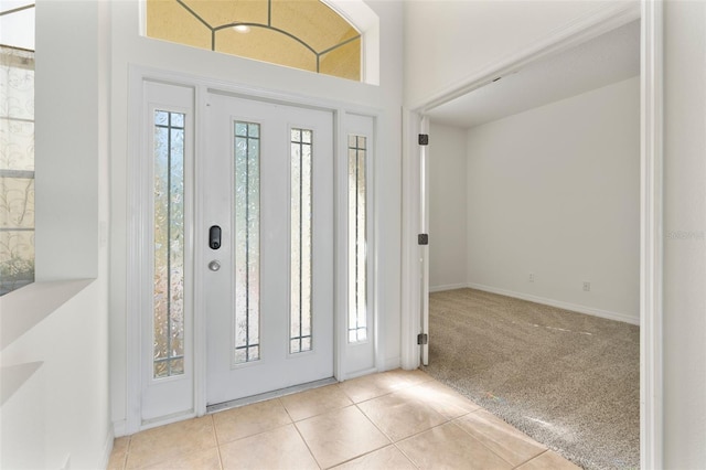 carpeted foyer entrance featuring tile patterned flooring and baseboards