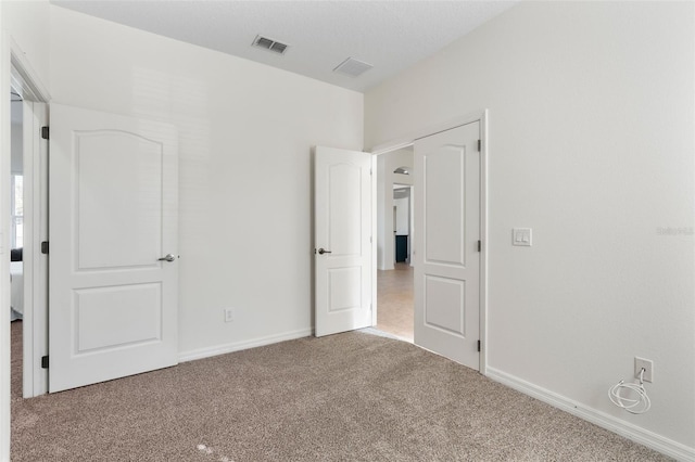 unfurnished bedroom with visible vents, baseboards, and carpet flooring